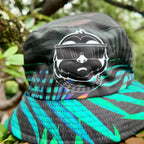 Close-up of the SLOTH character patch on the jungle side of the reversible bucket hat