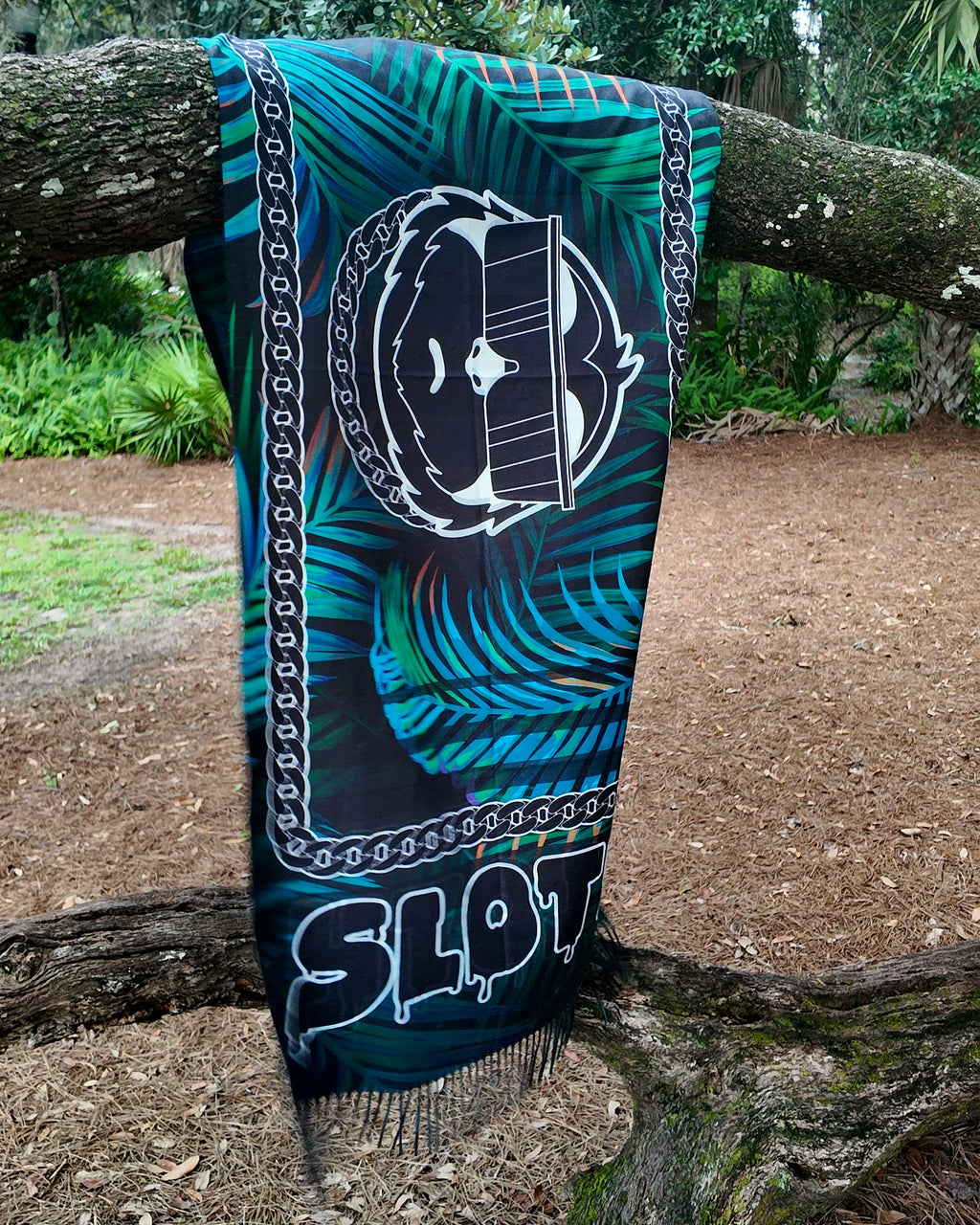 Full length of the SLOTH Jungle Pashmina hanging from a tree branch, showing the fringed ends